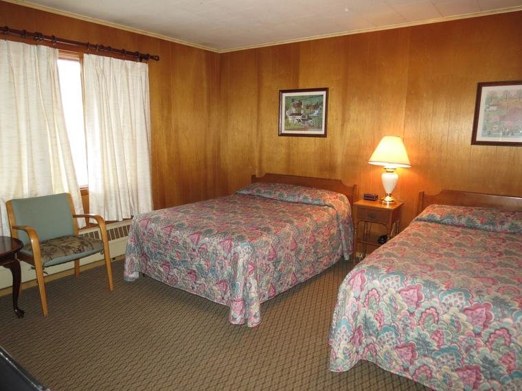 Standard room with two beds and wood-paneled walls