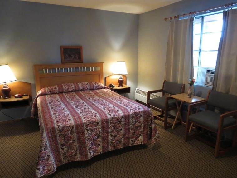 Standard room with a queen bed and sitting chairs