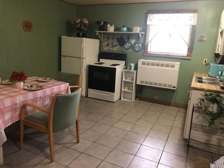Suite kitchen with stove, refrigerator and dining table
