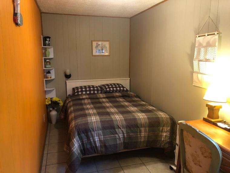 Suite bedroom with a plaid-covered bed