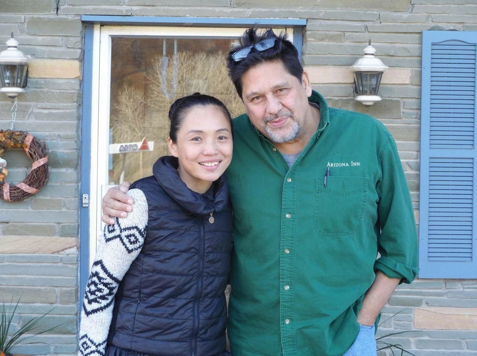 The innkeepers of Green Satori Inn standing outside the inn